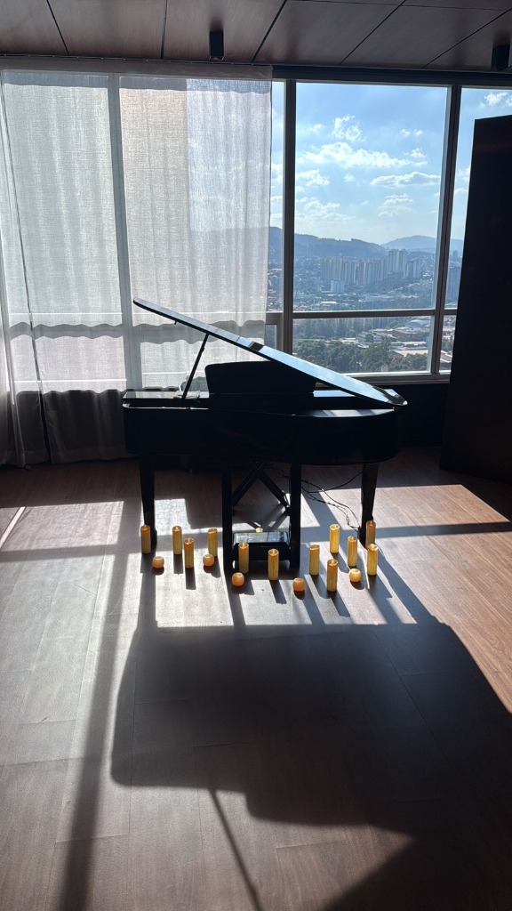 Piano de cauda preto em cobertura com luz natural